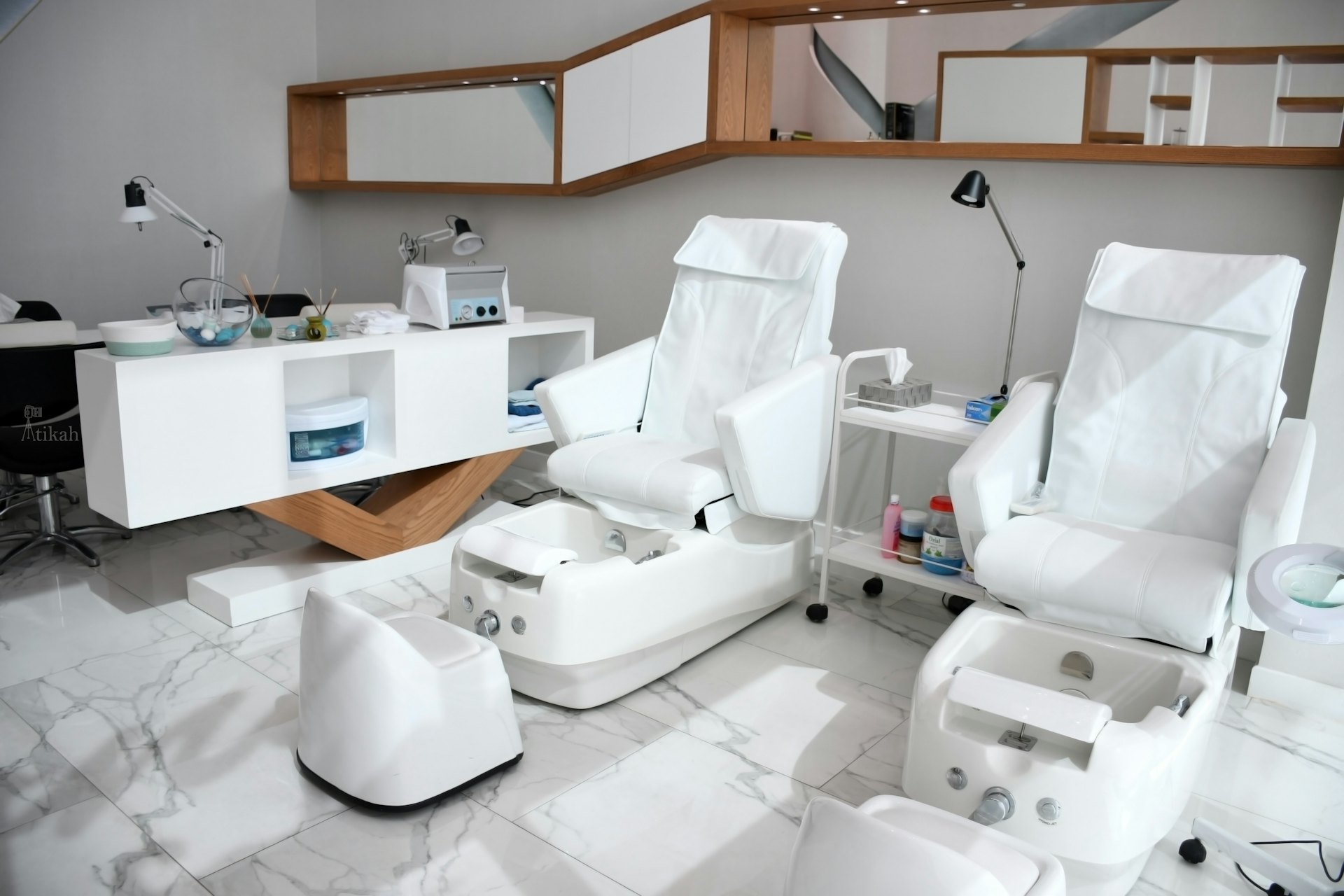 Beyaz pedikür ve bakım koltuklarıyla donatılmış güzellik salonu