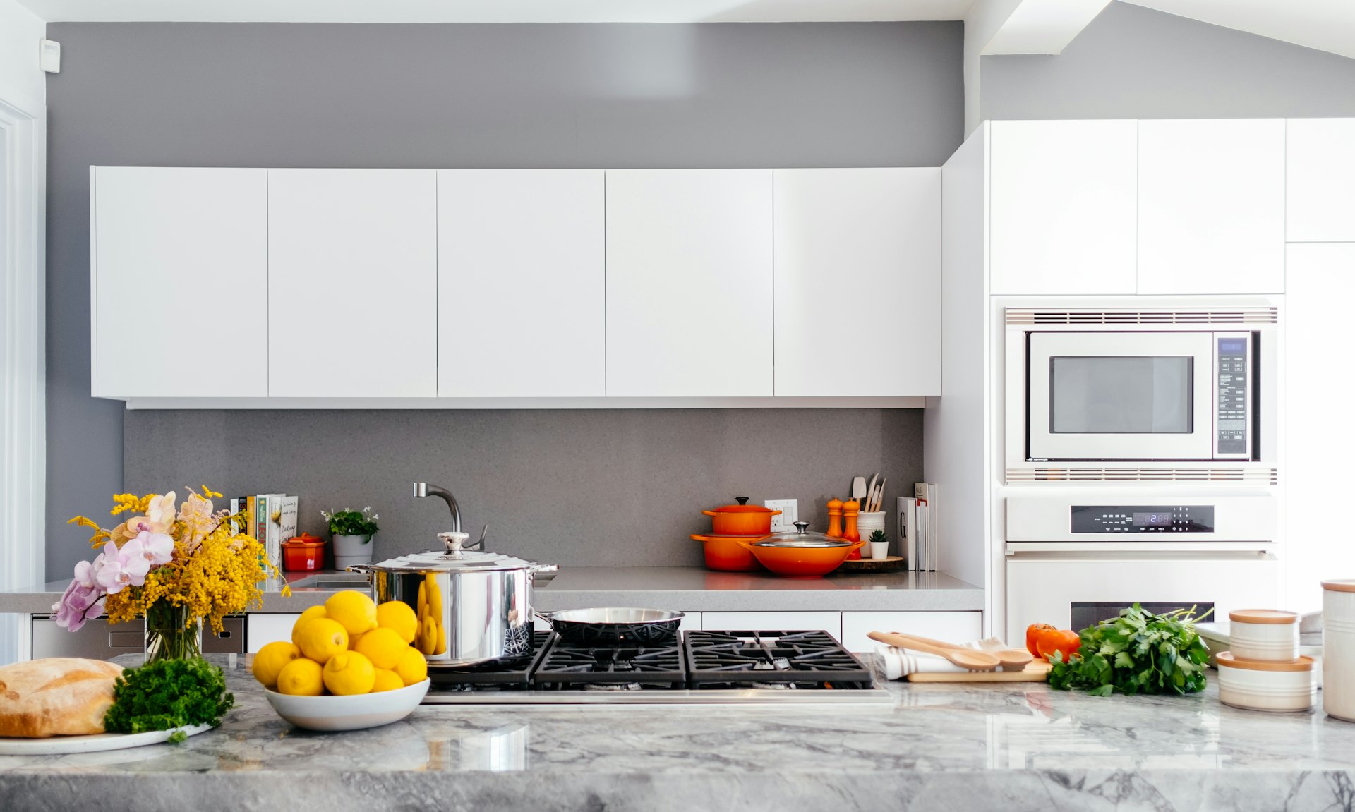Beyaz dolaplı ve mermer tezgâhlı aydınlık modern mutfak